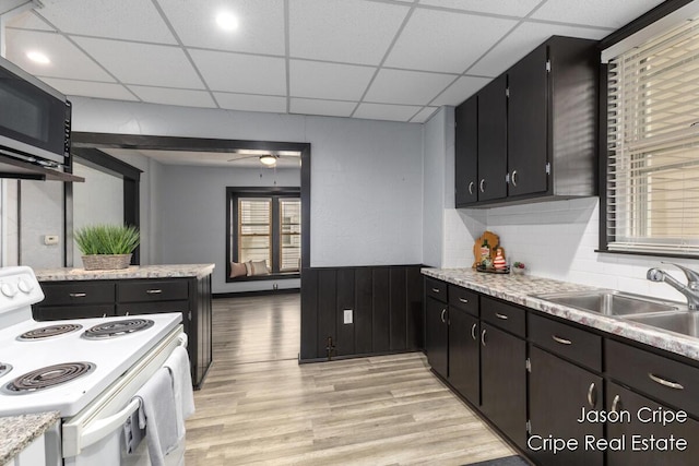 109 Fuller Ave SE, Grand Rapids, MI 49506 - kitchen featuring white range with electric stovetop, light wood-type flooring, stainless steel microwave, light countertops, and a drop ceiling