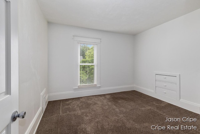109 Fuller Ave SE, Grand Rapids, MI 49506 - spare room featuring dark colored carpet and baseboards