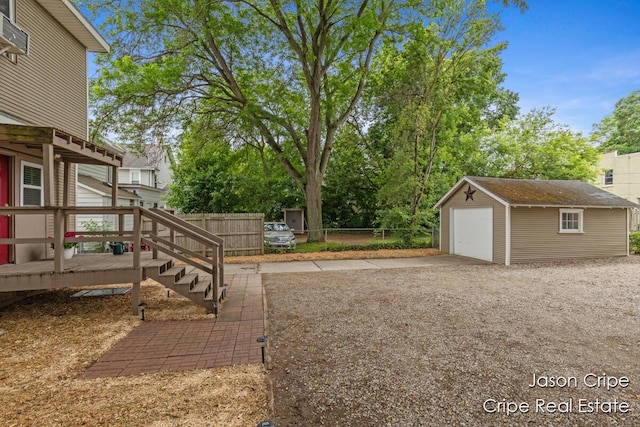 109 Fuller Ave SE, Grand Rapids, MI 49506 - view of yard featuring concrete driveway, a detached garage, an outbuilding, and a wooden deck
