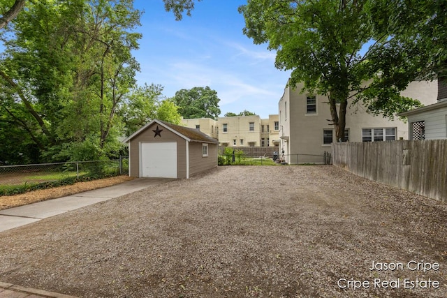 109 Fuller Ave SE, Grand Rapids, MI 49506 - view of yard featuring concrete driveway, a detached garage, and an outdoor structure