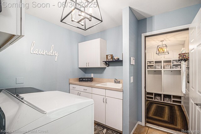 2868 Masters Ct, Pinckney, MI 48169 - laundry area featuring cabinet space, washer and clothes dryer, and a chandelier