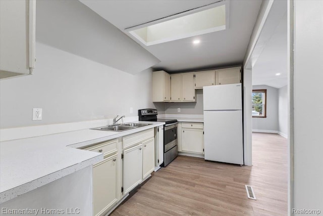 45866 Gable Inn St, Shelby Twp, MI 48317 - kitchen with freestanding refrigerator, stainless steel range with electric cooktop, light countertops, and light wood-style flooring