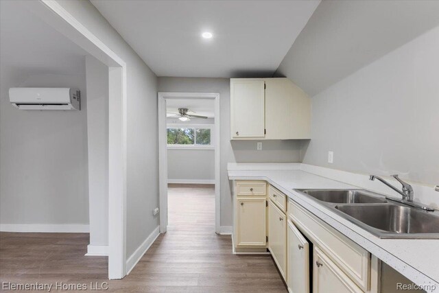 45866 Gable Inn St, Shelby Twp, MI 48317 - kitchen with a wall mounted air conditioner, wood finished floors, light countertops, and cream cabinets