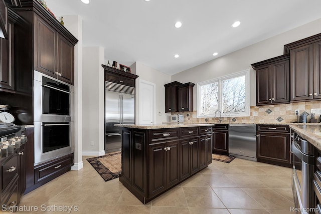 5001 Forest Vly, Clarkston, MI 48348 - kitchen featuring stainless steel appliances, backsplash, light stone countertops, dark brown cabinets, and recessed lighting