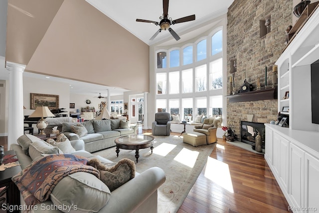 5001 Forest Vly, Clarkston, MI 48348 - living room featuring decorative columns, a ceiling fan, ornamental molding, a high ceiling, and wood-type flooring