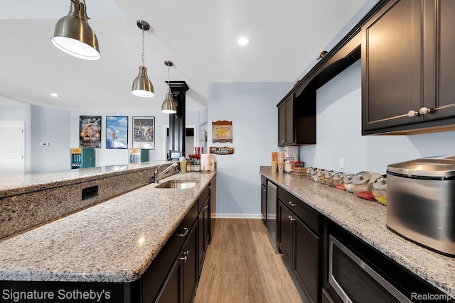 5001 Forest Vly, Clarkston, MI 48348 - kitchen featuring light wood-style floors, light stone countertops, wine cooler, decorative light fixtures, and a peninsula