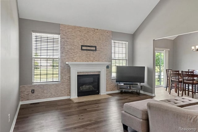 70298 Sunny Brook Ln, Macomb, MI 48062 - living room with plenty of natural light, wood finished floors, vaulted ceiling, a fireplace with flush hearth, and a chandelier