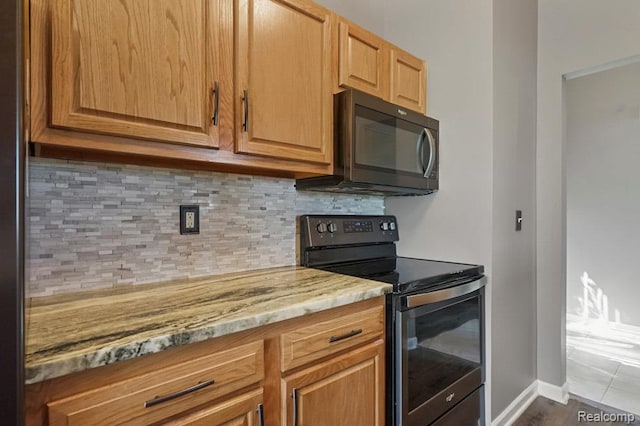 70298 Sunny Brook Ln, Macomb, MI 48062 - kitchen featuring black appliances, tasteful backsplash, and light stone countertops
