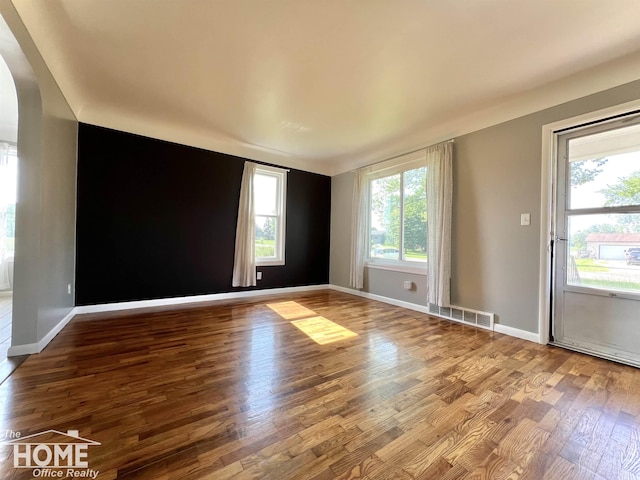 10306 Reid Rd, Swartz Creek, MI 48473 - spare room featuring arched walkways and wood finished floors