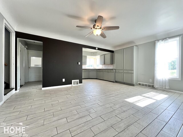10306 Reid Rd, Swartz Creek, MI 48473 - unfurnished living room featuring a ceiling fan and light wood-type flooring