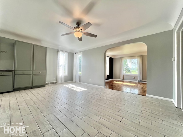 10306 Reid Rd, Swartz Creek, MI 48473 - spare room with arched walkways, ceiling fan, and light wood finished floors