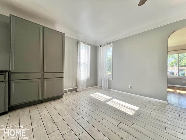 10306 Reid Rd, Swartz Creek, MI 48473 - spare room featuring arched walkways, light wood-style flooring, and ceiling fan