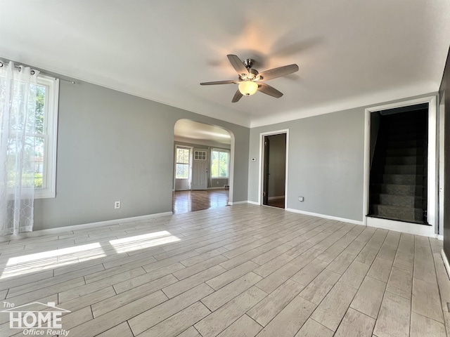 10306 Reid Rd, Swartz Creek, MI 48473 - spare room featuring arched walkways, ceiling fan, and light wood-style floors