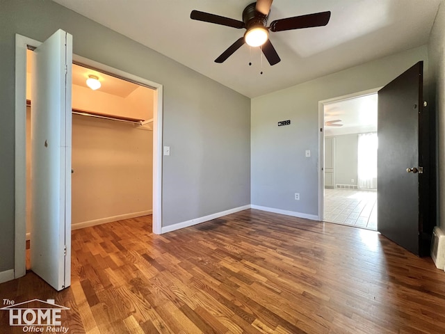 10306 Reid Rd, Swartz Creek, MI 48473 - unfurnished bedroom featuring wood finished floors, a spacious closet, a closet, and ceiling fan