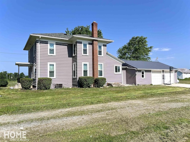 10306 Reid Rd, Swartz Creek, MI 48473 - rear view of property featuring a chimney, a garage, a lawn, and concrete driveway