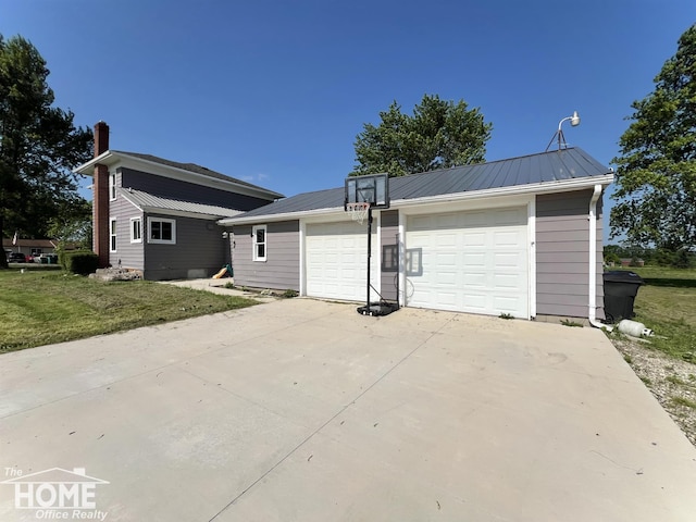 10306 Reid Rd, Swartz Creek, MI 48473 - view of front facade with a garage, a metal roof, a front lawn, and concrete driveway