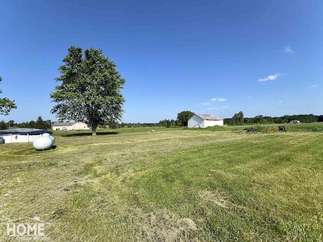 10306 Reid Rd, Swartz Creek, MI 48473 - view of grassy yard with a rural view and an outdoor structure