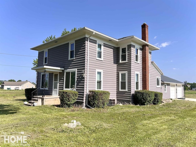 10306 Reid Rd, Swartz Creek, MI 48473 - rear view of property featuring a chimney, a lawn, and a garage