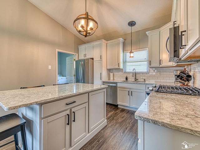 5257 Torrington Dr, Monroe, MI 48161 - kitchen with appliances with stainless steel finishes, a center island, decorative backsplash, dark wood-style floors, and pendant lighting