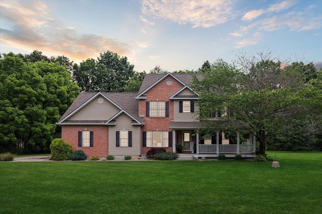 6212 Sagamore Ln, Kalamazoo, MI 49004 - view of front facade featuring brick siding, a yard, covered porch, and roof with shingles