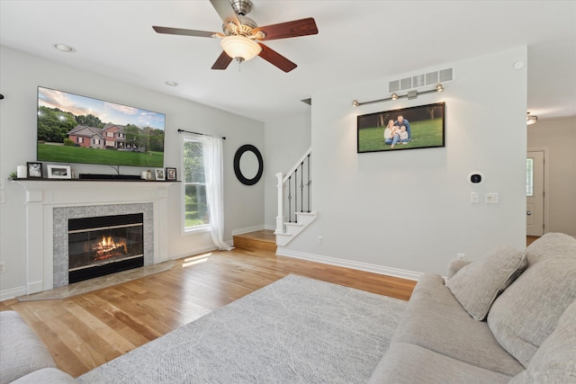 6212 Sagamore Ln, Kalamazoo, MI 49004 - living room with wood finished floors, ceiling fan, stairs, and a tiled fireplace