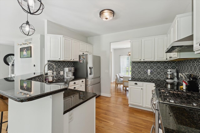 6212 Sagamore Ln, Kalamazoo, MI 49004 - kitchen with stainless steel appliances, a peninsula, backsplash, a kitchen breakfast bar, and white cabinets