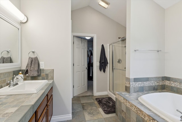 6212 Sagamore Ln, Kalamazoo, MI 49004 - bathroom featuring a bath, a shower stall, vanity, lofted ceiling, and a walk in closet