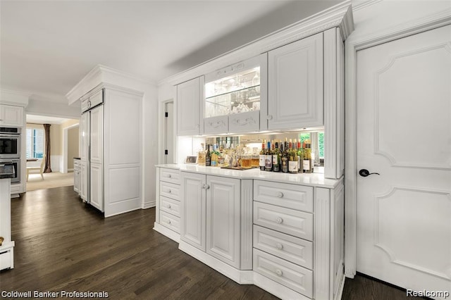 4462 Barchester Dr, Bloomfield Hills, MI 48302 - indoor dry bar featuring stainless steel double oven, dark wood finished floors, and ornamental molding