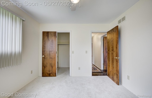 45264 Universal Ct, Shelby Twp, MI 48317 - unfurnished bedroom with carpet, a spacious closet, a ceiling fan, and a closet