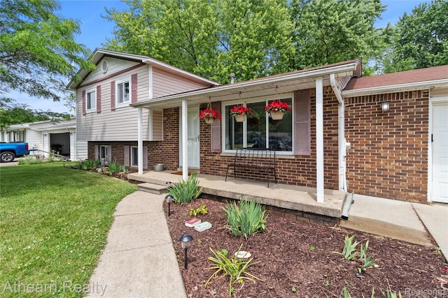 4438 Bridgeman Trl, Swartz Creek, MI 48473 - split level home featuring covered porch, brick siding, a front lawn, and a garage