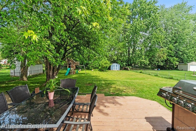 4438 Bridgeman Trl, Swartz Creek, MI 48473 - wooden terrace with a playground, a shed, outdoor dining space, a fenced backyard, and a grill