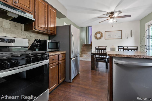 4438 Bridgeman Trl, Swartz Creek, MI 48473 - kitchen with stainless steel appliances, under cabinet range hood, tasteful backsplash, a ceiling fan, and dark wood-style floors