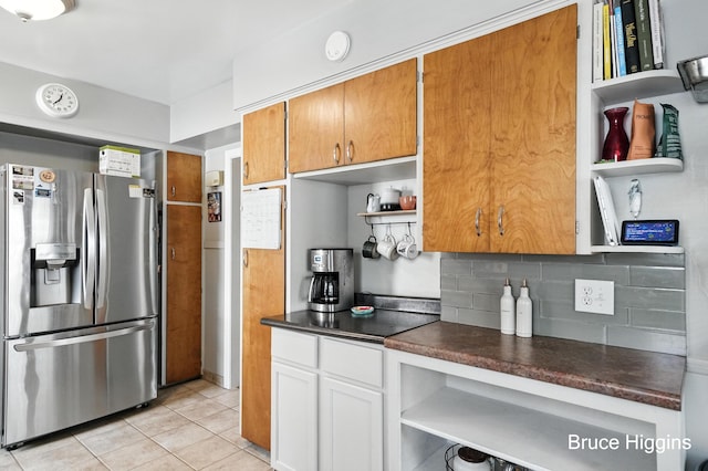 920 Graceland St NE, Grand Rapids, MI 49505 - kitchen with stainless steel fridge, open shelves, dark countertops, light tile patterned flooring, and tasteful backsplash