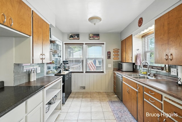 920 Graceland St NE, Grand Rapids, MI 49505 - kitchen featuring appliances with stainless steel finishes, dark countertops, brown cabinets, and a wainscoted wall