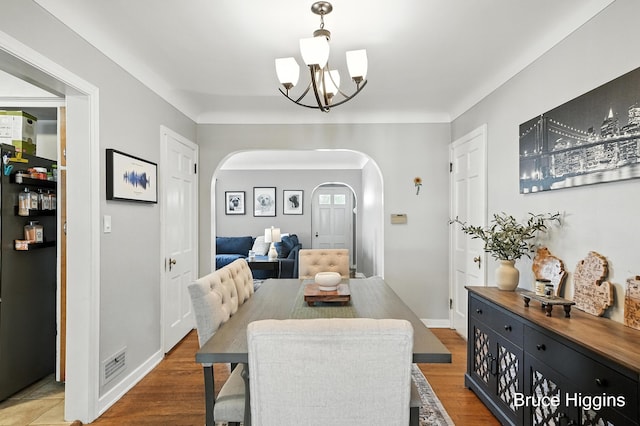 920 Graceland St NE, Grand Rapids, MI 49505 - dining room featuring arched walkways, a chandelier, and wood finished floors