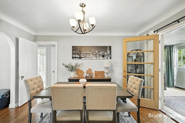 920 Graceland St NE, Grand Rapids, MI 49505 - dining area featuring a chandelier, wood finished floors, and arched walkways