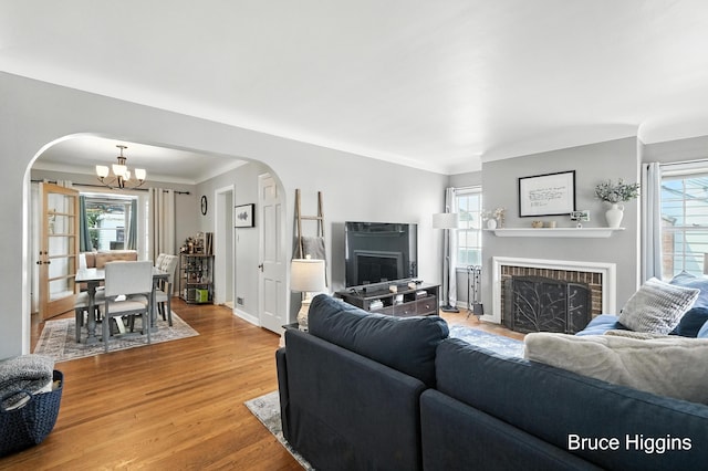 920 Graceland St NE, Grand Rapids, MI 49505 - living room featuring arched walkways, a fireplace, a chandelier, and crown molding