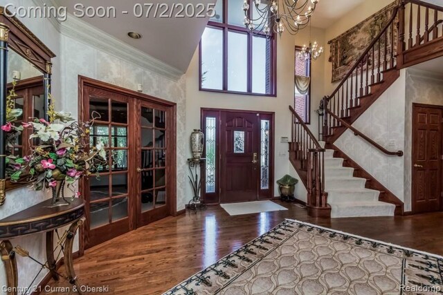 31085 Estate Woods Ct, Farmington Hills, MI 48331 - entrance foyer featuring a towering ceiling, wood finished floors, a chandelier, stairs, and crown molding