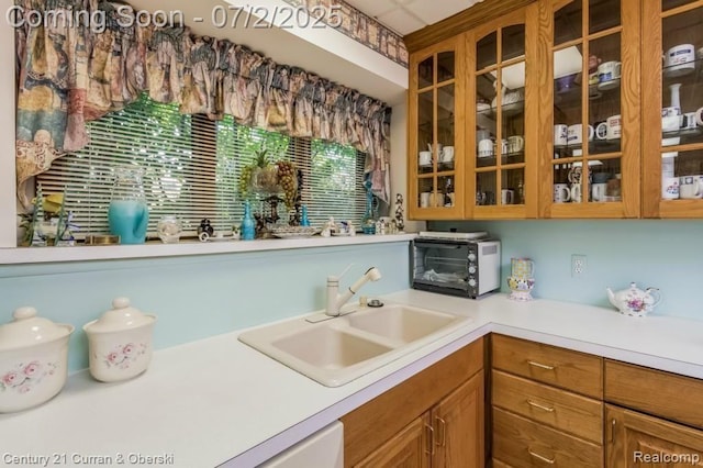 31085 Estate Woods Ct, Farmington Hills, MI 48331 - kitchen featuring light countertops, glass insert cabinets, and brown cabinetry