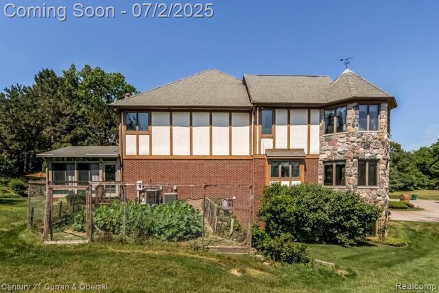31085 Estate Woods Ct, Farmington Hills, MI 48331 - rear view of property featuring a lawn, stone siding, stucco siding, and brick siding