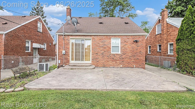 9269 Hubert Ave, Taylor, MI 48101 - rear view of house with a chimney, brick siding, and a patio