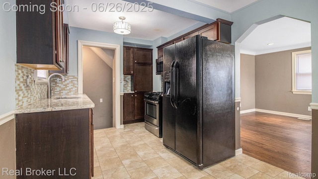 9269 Hubert Ave, Taylor, MI 48101 - kitchen featuring stainless steel appliances, tasteful backsplash, dark brown cabinetry, and light stone counters