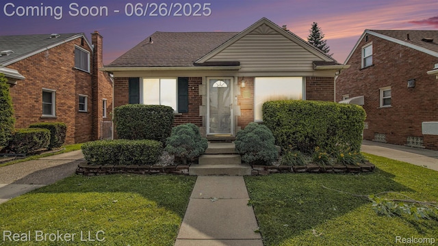 9269 Hubert Ave, Taylor, MI 48101 - view of front of house featuring a front lawn, brick siding, roof with shingles, and a chimney