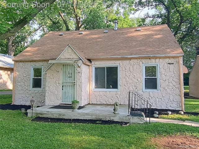 19241 Melrose Ave, Southfield, MI 48075 - view of front of house with a shingled roof, a front yard, and stone siding