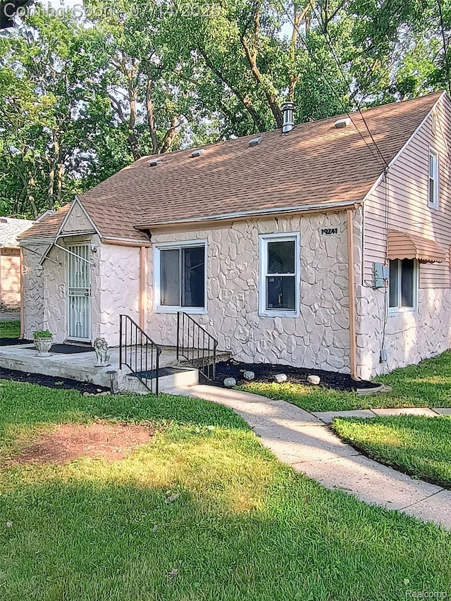 19241 Melrose Ave, Southfield, MI 48075 - view of front facade featuring a shingled roof, stone siding, and a front lawn