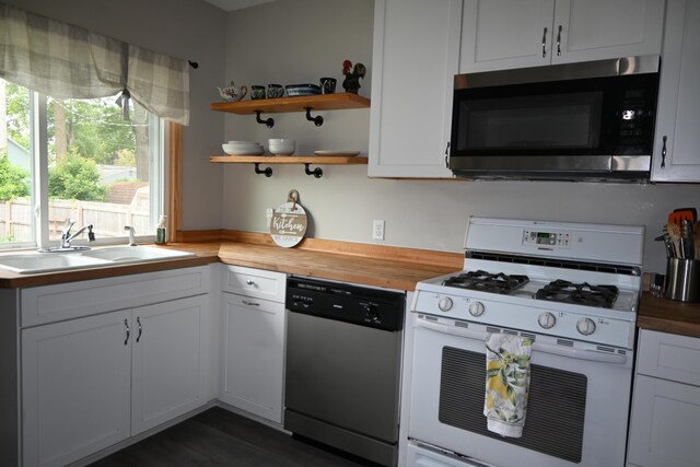 2245 Morton Ave, Muskegon, MI 49441 - kitchen with appliances with stainless steel finishes, butcher block countertops, open shelves, and white cabinetry