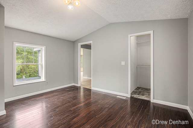 6973 W Blue Water Hwy, Saranac, MI 48881 - unfurnished bedroom featuring a textured ceiling, wood-type flooring, lofted ceiling, and a closet