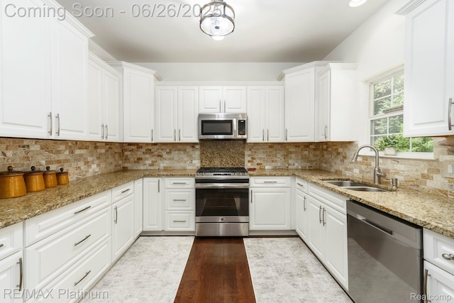 182 Fairhill Way, Howell, MI 48843 - kitchen featuring stainless steel appliances, light wood-type flooring, white cabinets, light stone countertops, and backsplash