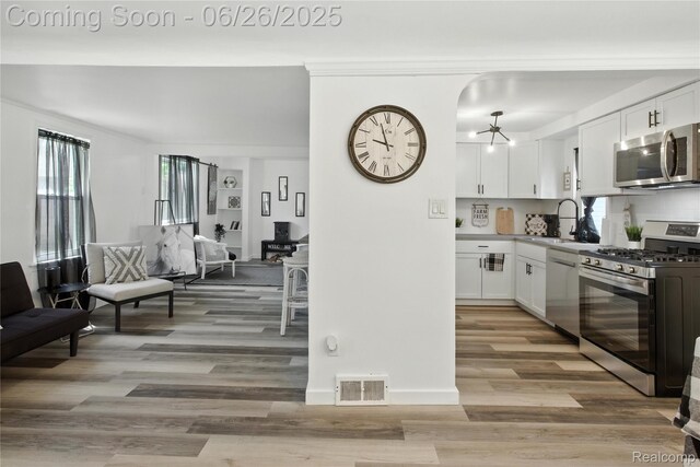 8411 Hugh St, Westland, MI 48185 - kitchen featuring appliances with stainless steel finishes, white cabinets, light wood finished floors, and light countertops