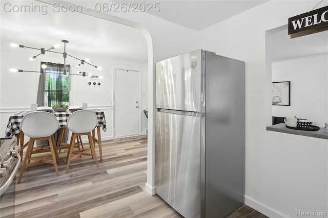 8411 Hugh St, Westland, MI 48185 - kitchen featuring appliances with stainless steel finishes, wood finished floors, and a chandelier
